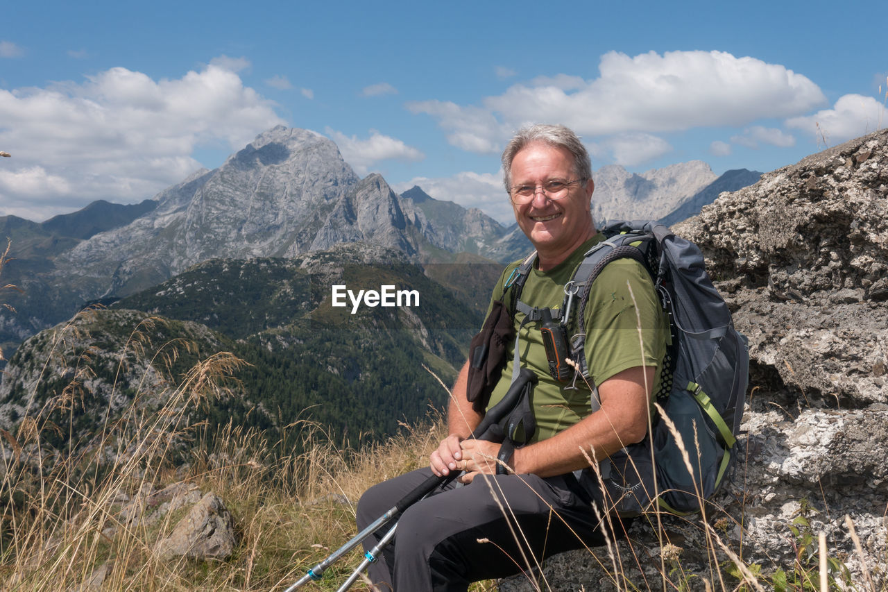 Smiling old hiker on the mountain top. alps italy