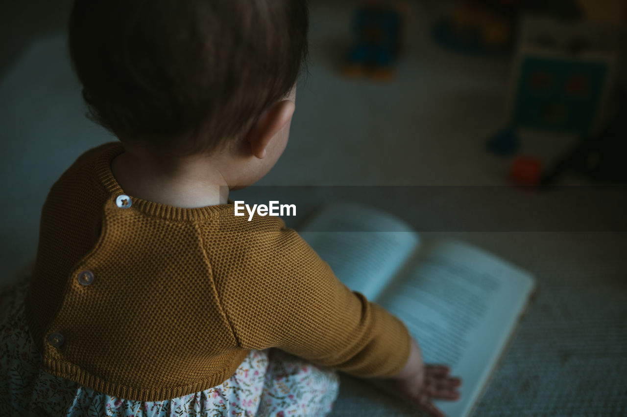 Close-up of girl reading book at home