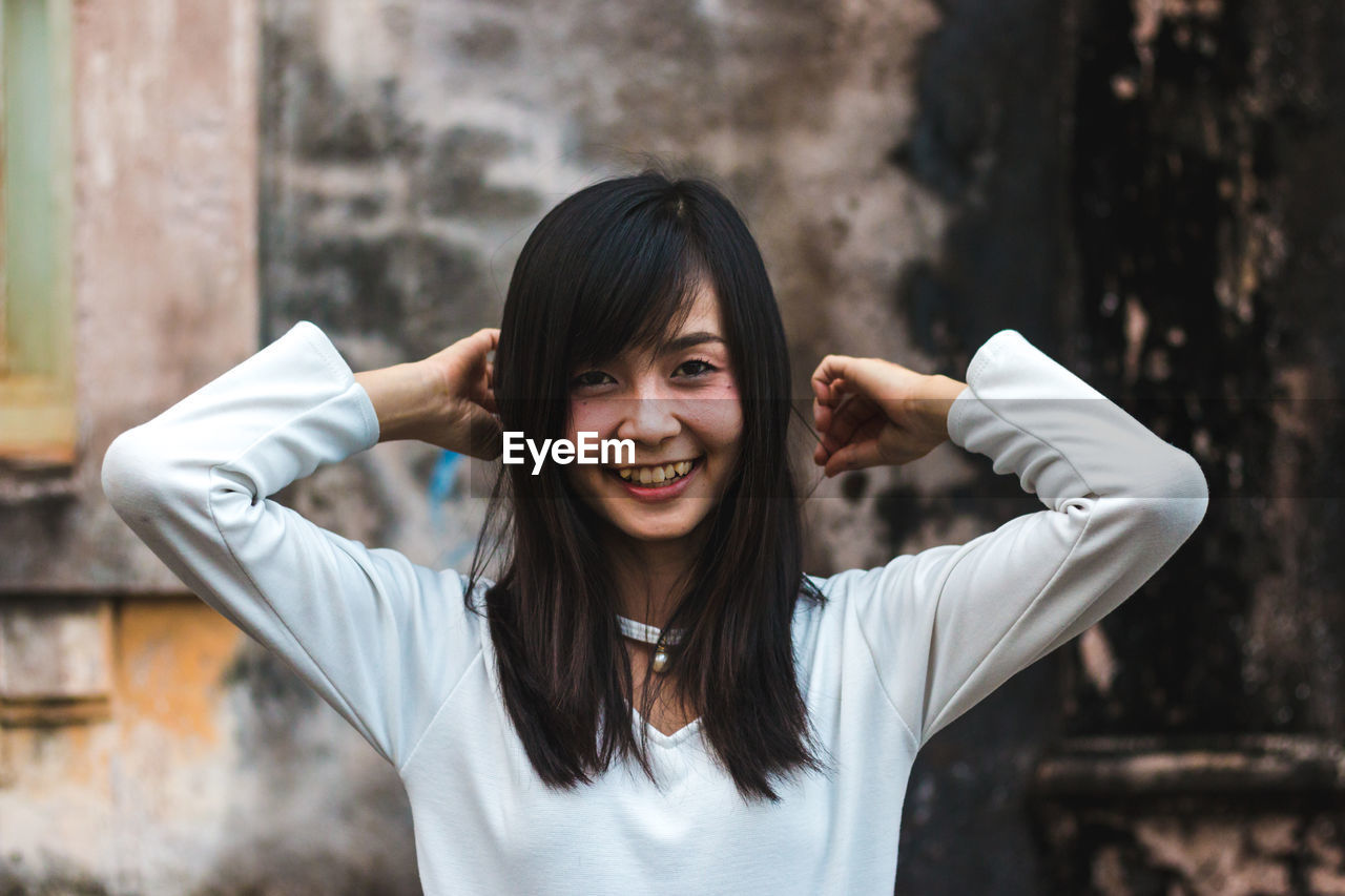 Portrait of smiling young woman standing outdoors