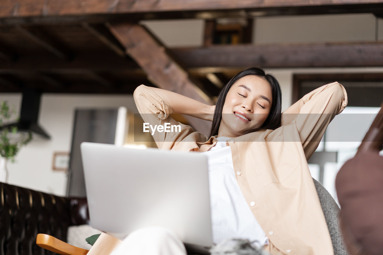 portrait of young woman using digital tablet while sitting at home