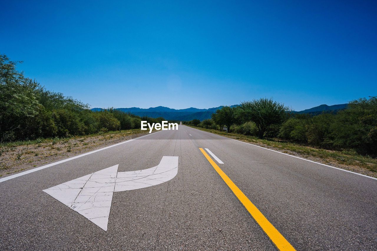 Empty road against blue sky