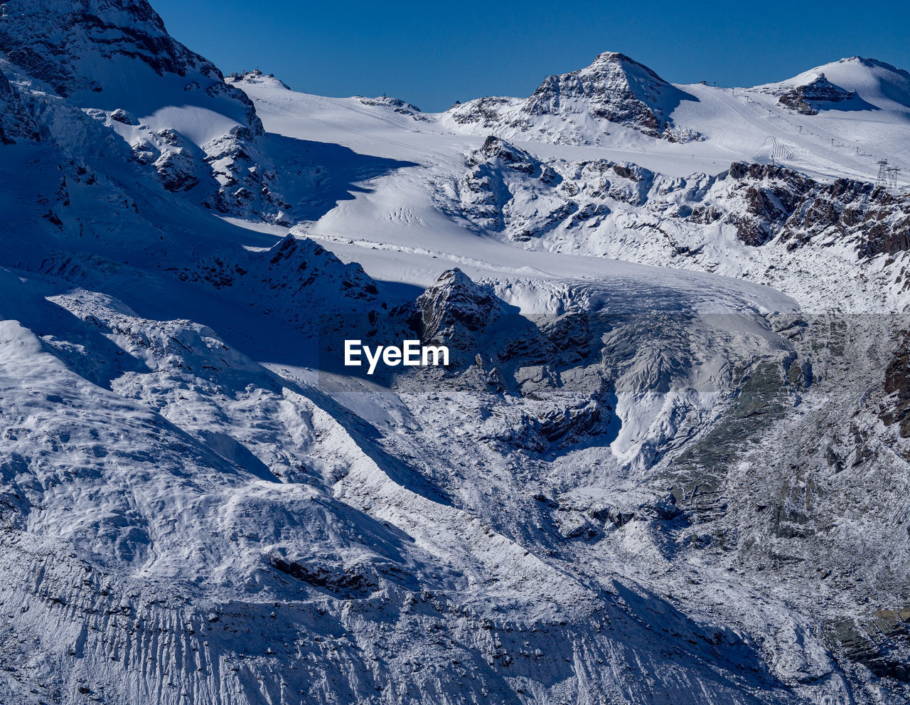 Scenic view of a glacier and snowcapped mountains against sky
