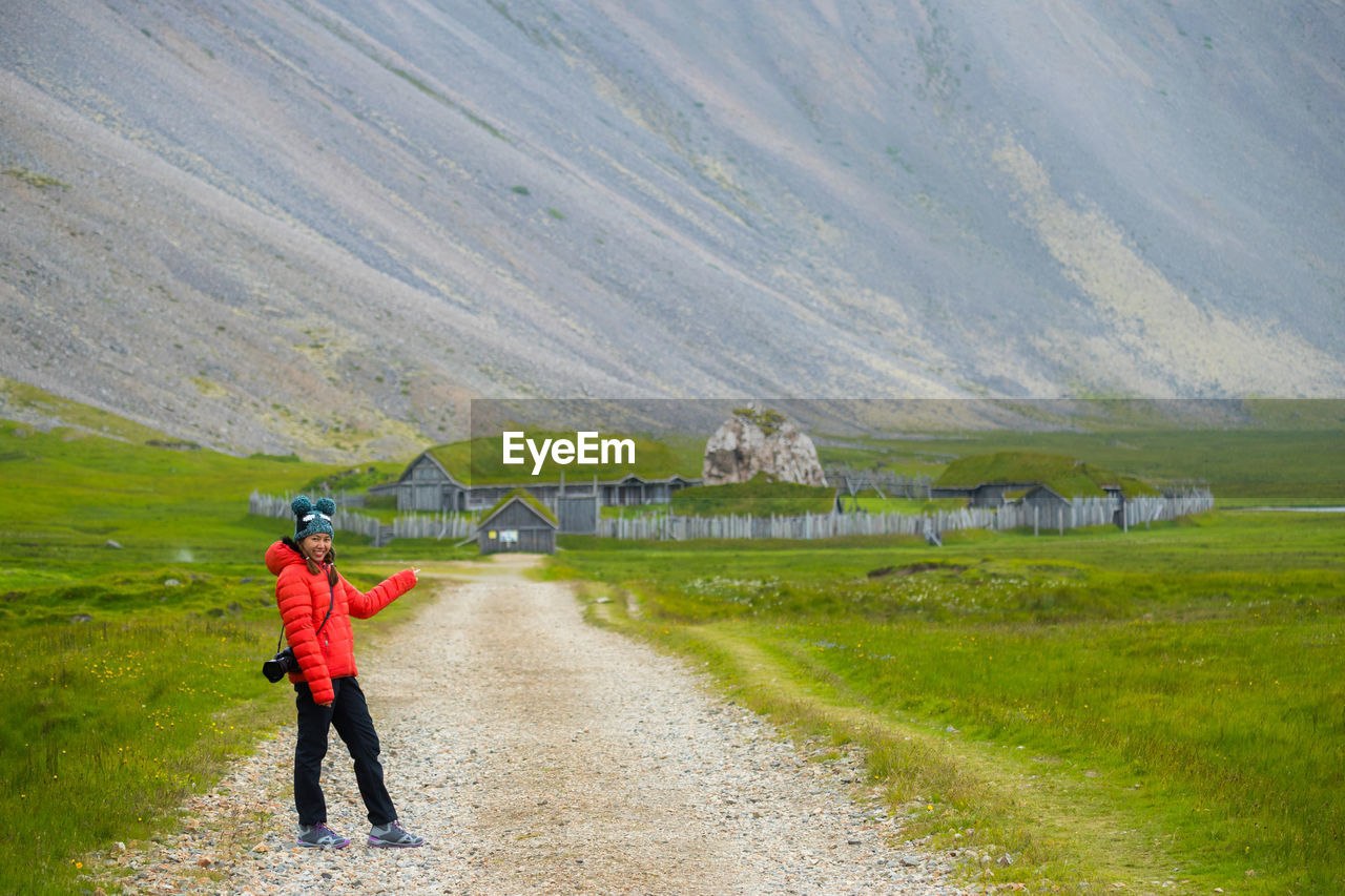 FULL LENGTH REAR VIEW OF MAN STANDING ON LANDSCAPE