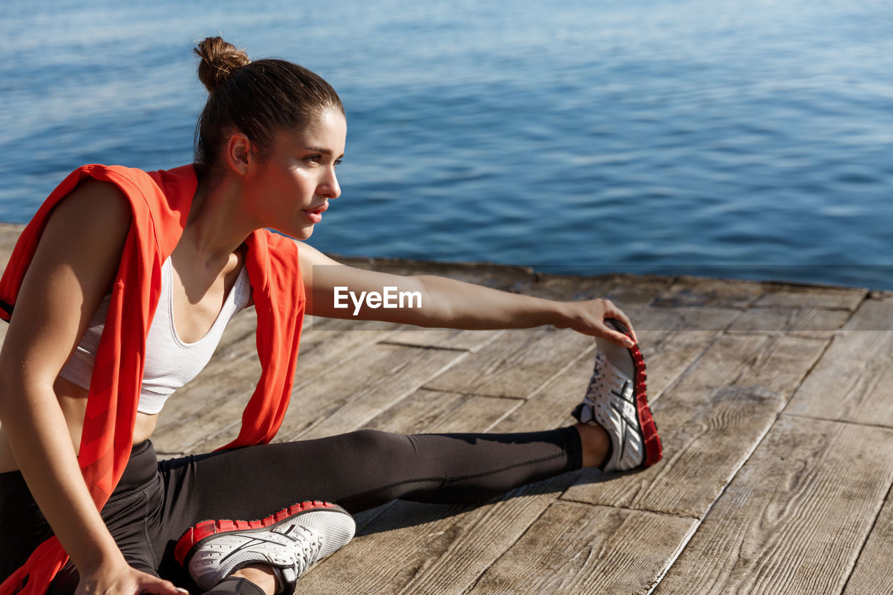 High angle view of woman exercising while sitting on floor