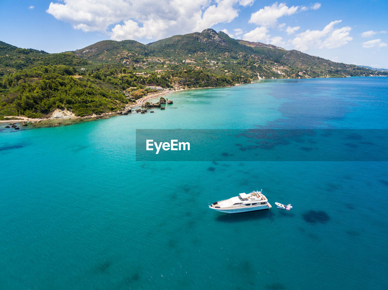 Aerial view of boat in sea against mountains and sky
