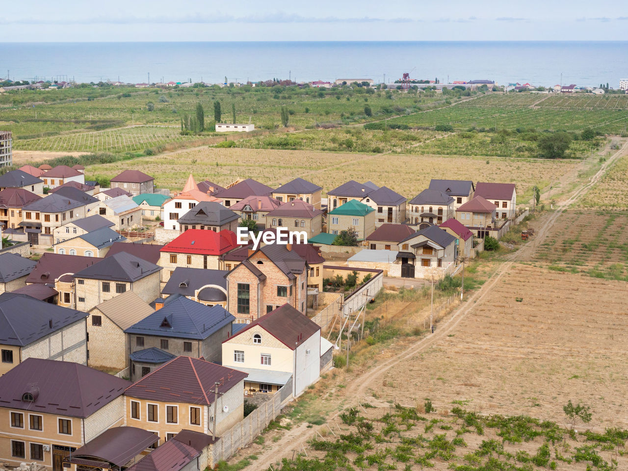 HIGH ANGLE VIEW OF HOUSES AMIDST TREES AND BUILDINGS