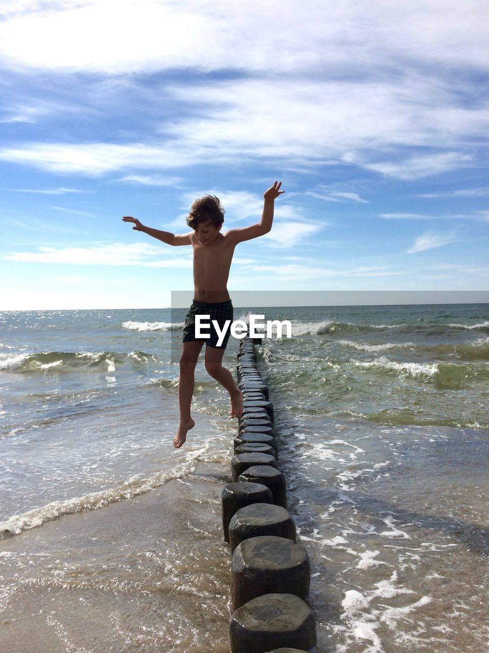 REAR VIEW OF PERSON STANDING ON BEACH