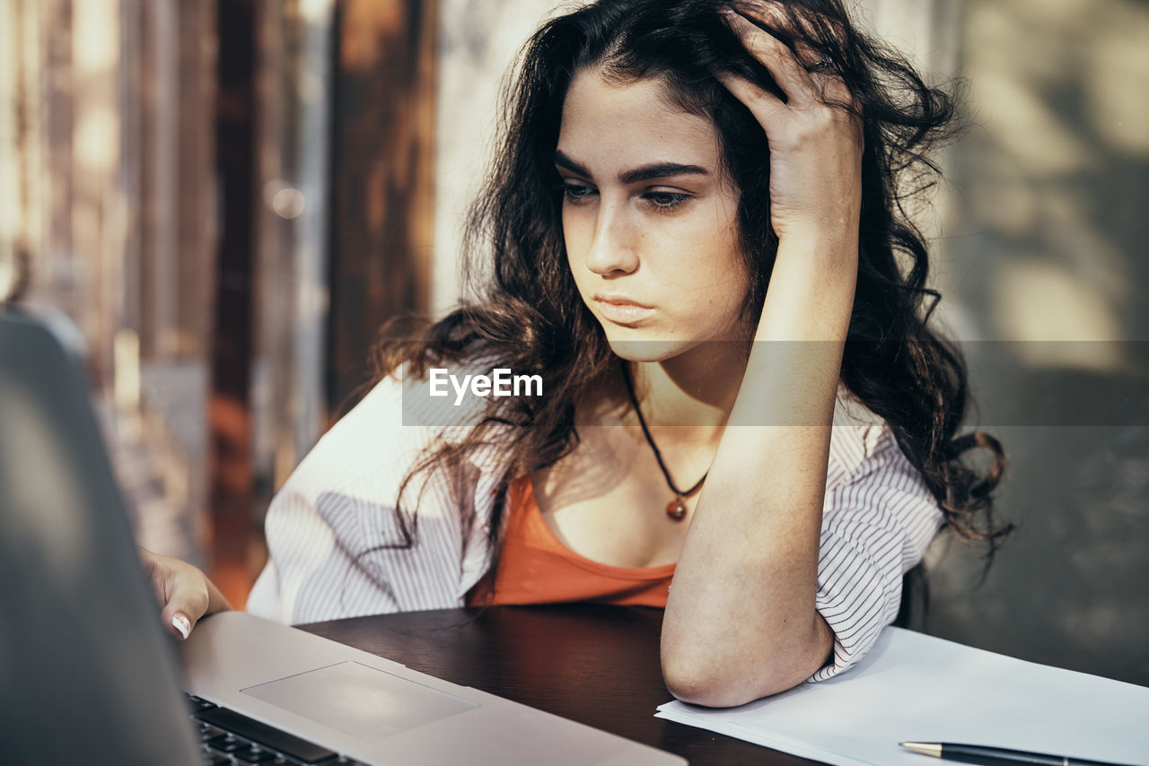 portrait of young woman using laptop at home