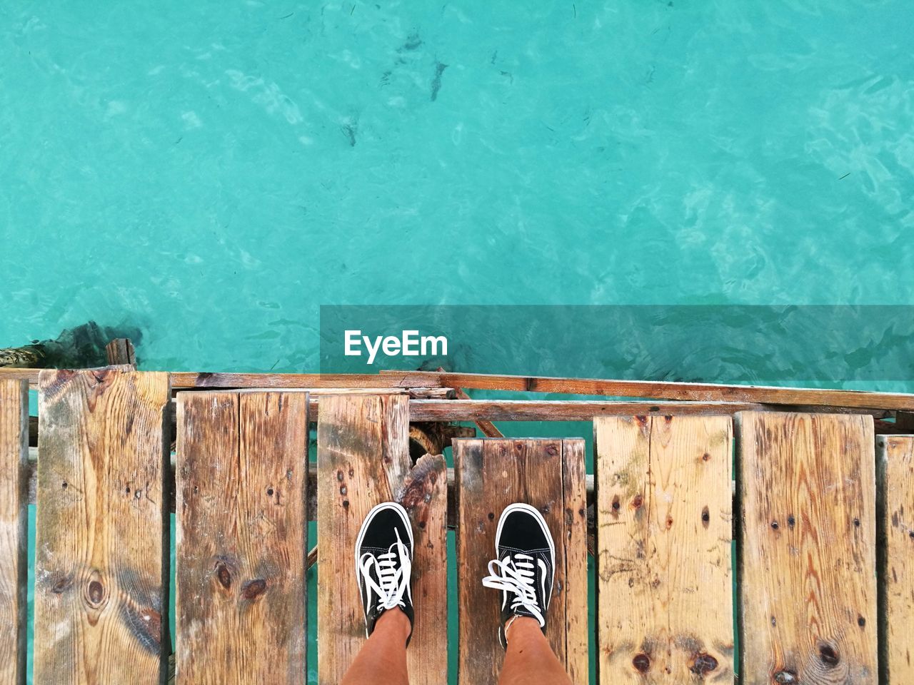 LOW SECTION OF PERSON STANDING ON SWIMMING POOL