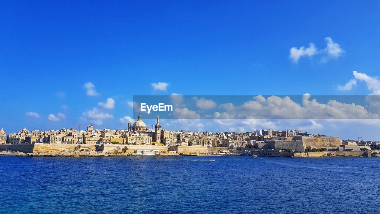 Panoramic view of sea and buildings against sky