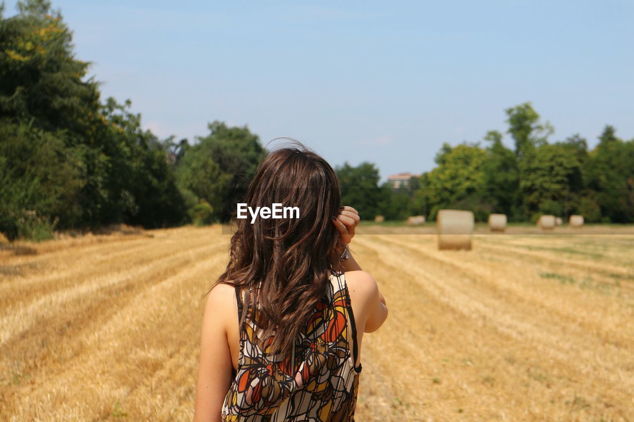 Rear view of woman standing on field