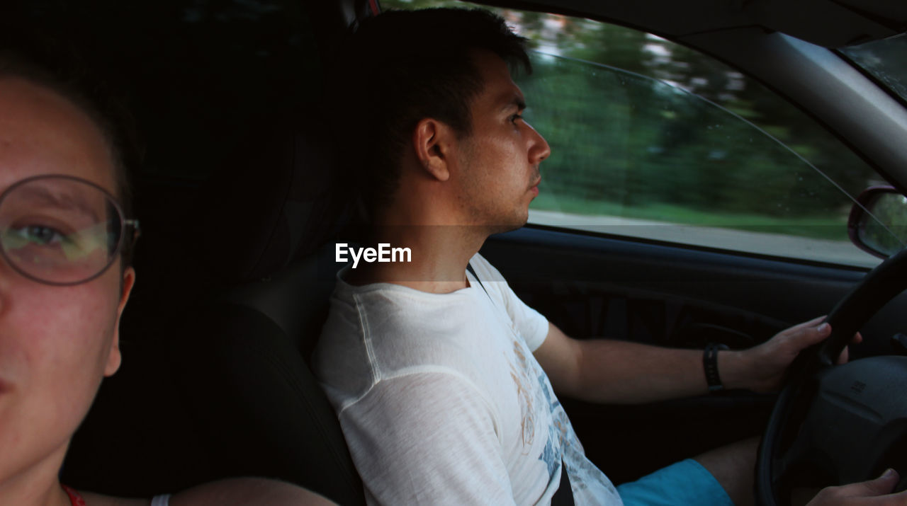 Portrait of woman sitting in car with man