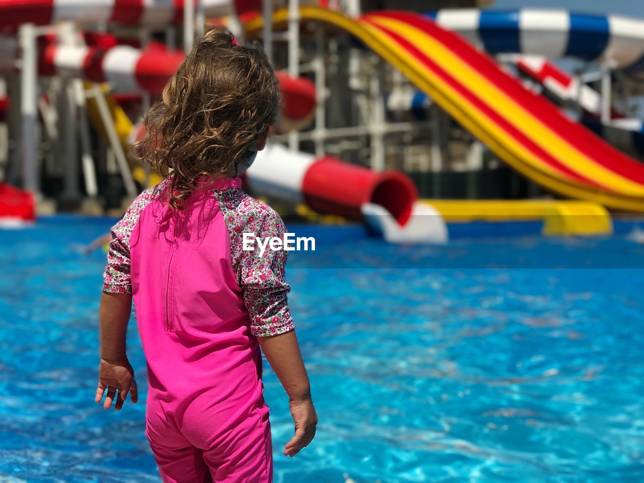 Rear view of girl standing at water park