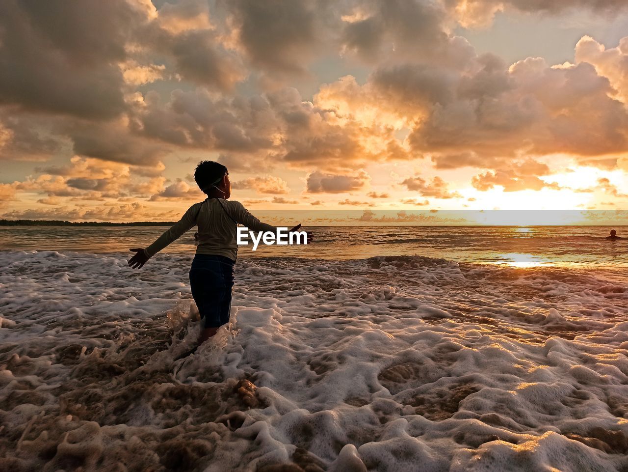 Man on beach against sky during sunset