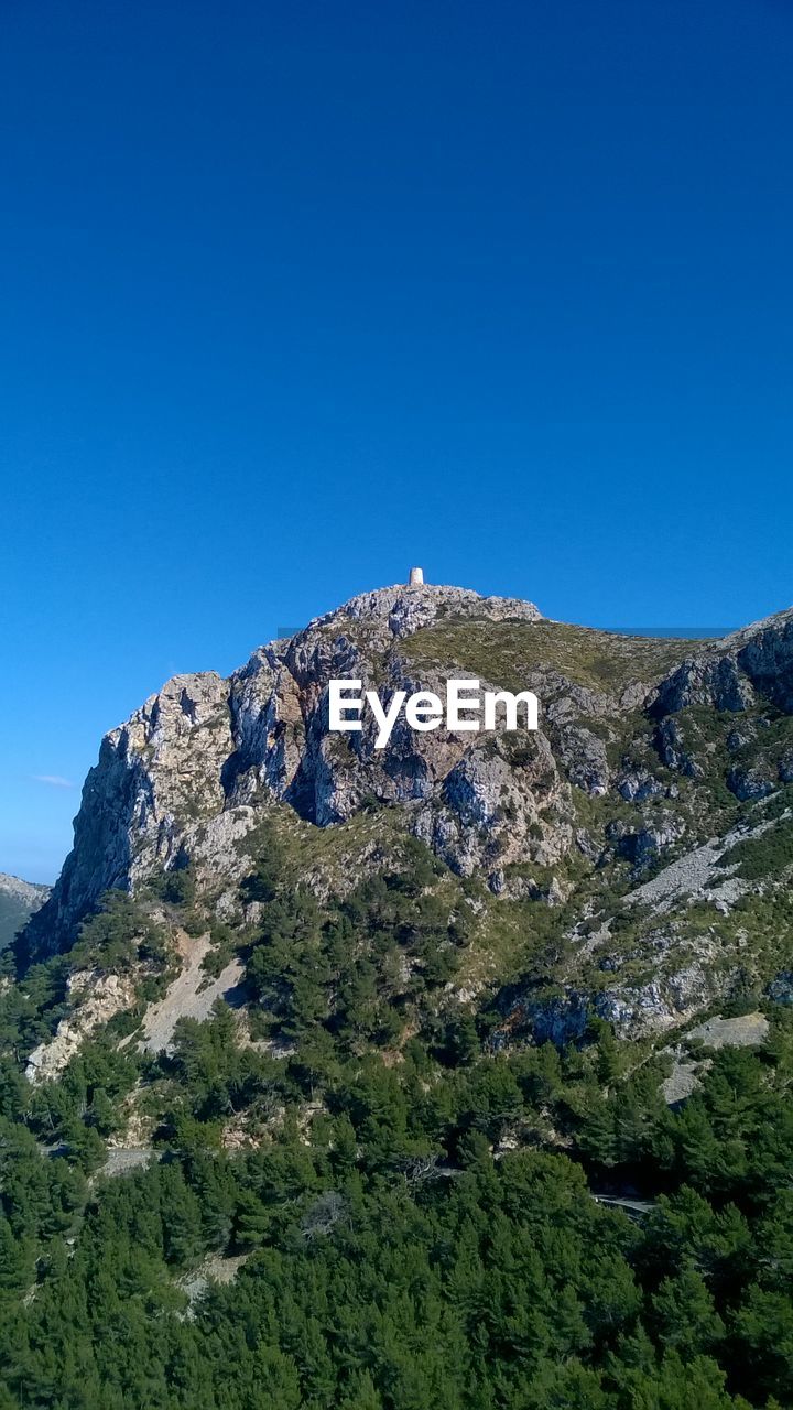 LOW ANGLE VIEW OF MOUNTAIN AGAINST CLEAR BLUE SKY