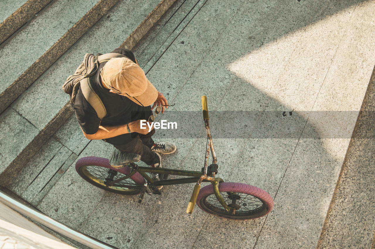 High angle view of man with bicycle on staircase