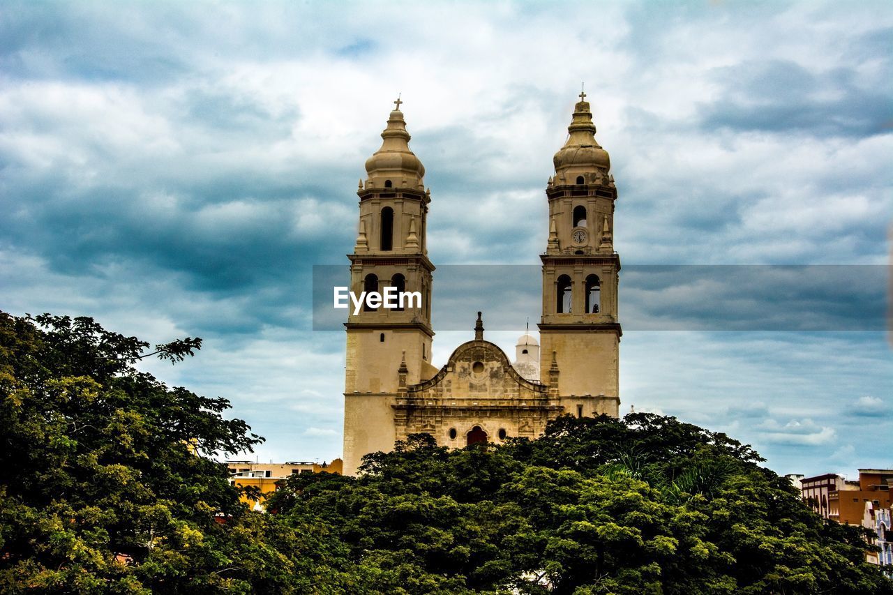 Low angle view of campeche cathedral against cloudy sky