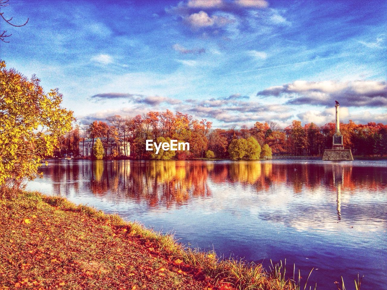 Scenic view of lake with autumn trees against sky