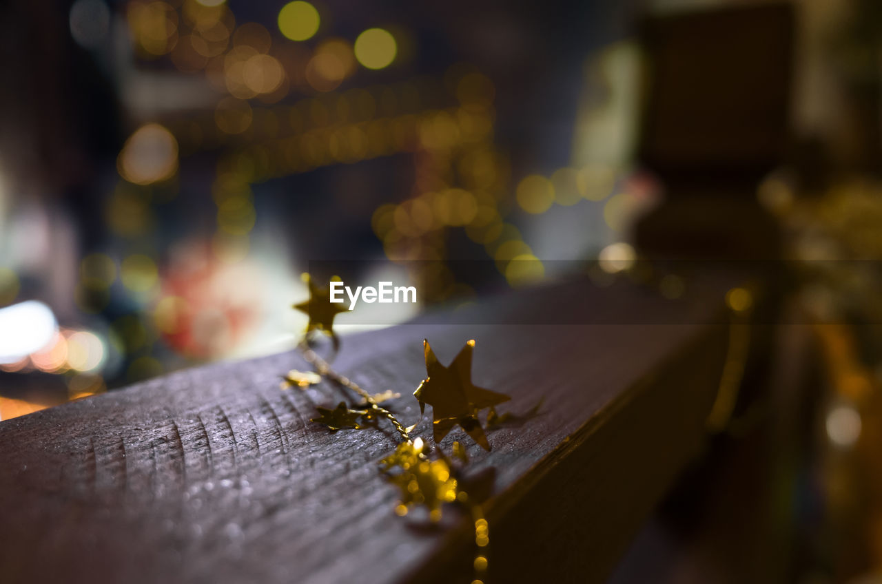 Close-up of gold star shape decorations on railing during christmas