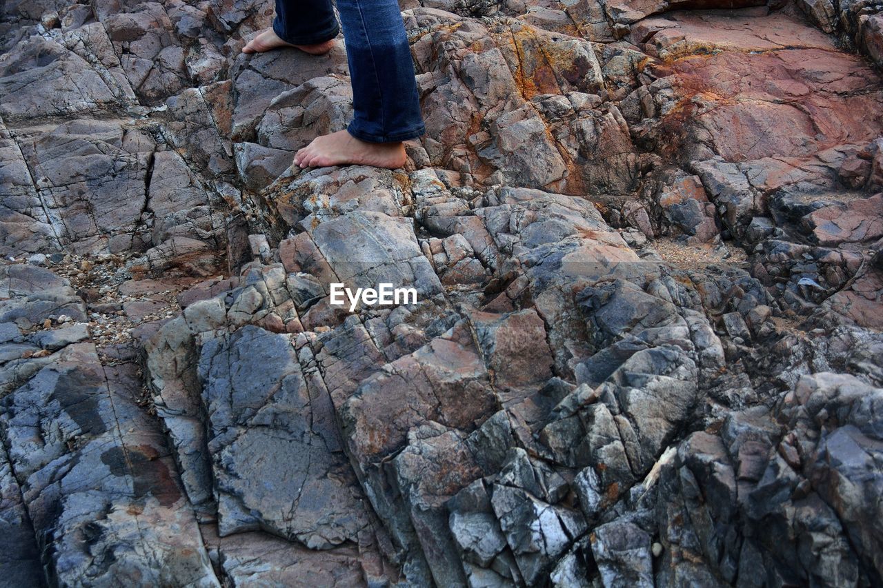 Low section of person walking on rocks