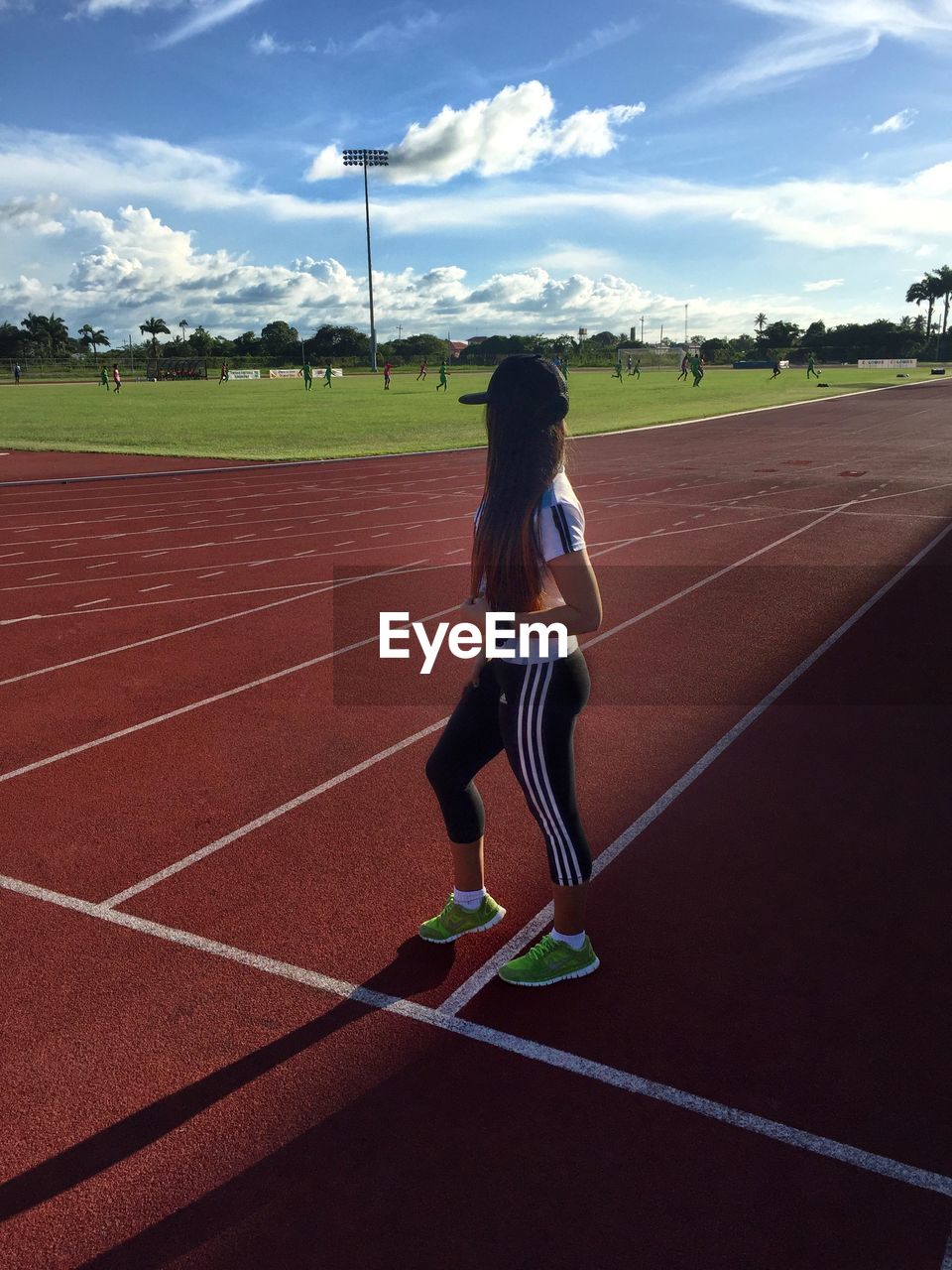 Side view of woman standing on sports track