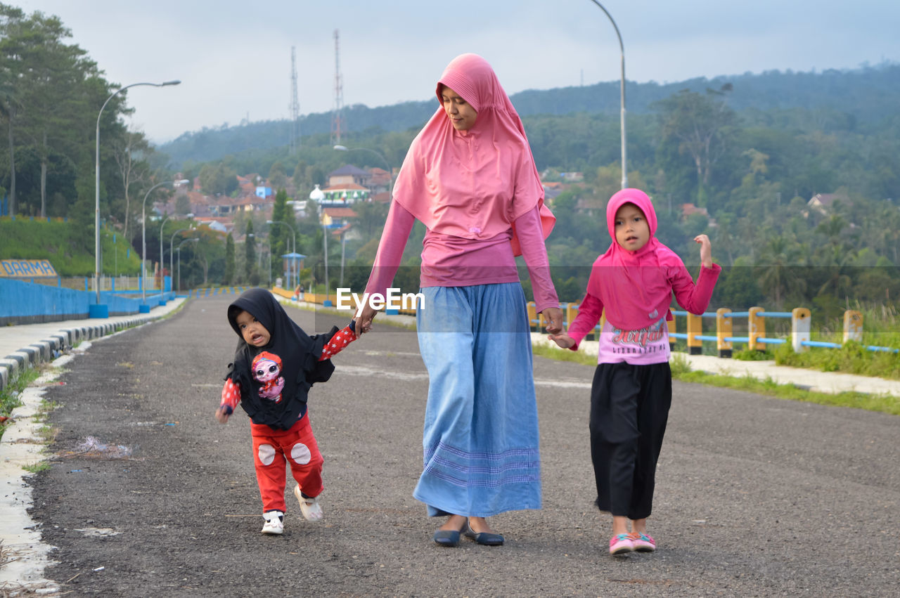 Full length of mother and girl on road