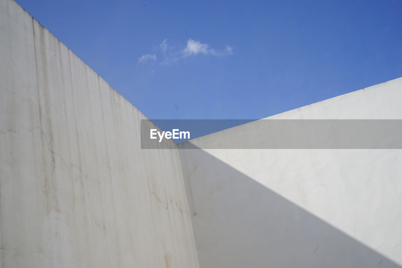 LOW ANGLE VIEW OF BUILT STRUCTURE AGAINST BLUE SKY