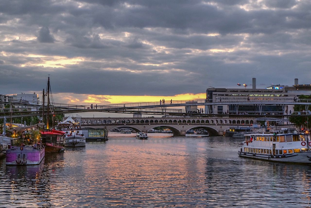 BOATS MOORED AT RIVER AGAINST CLOUDY SKY