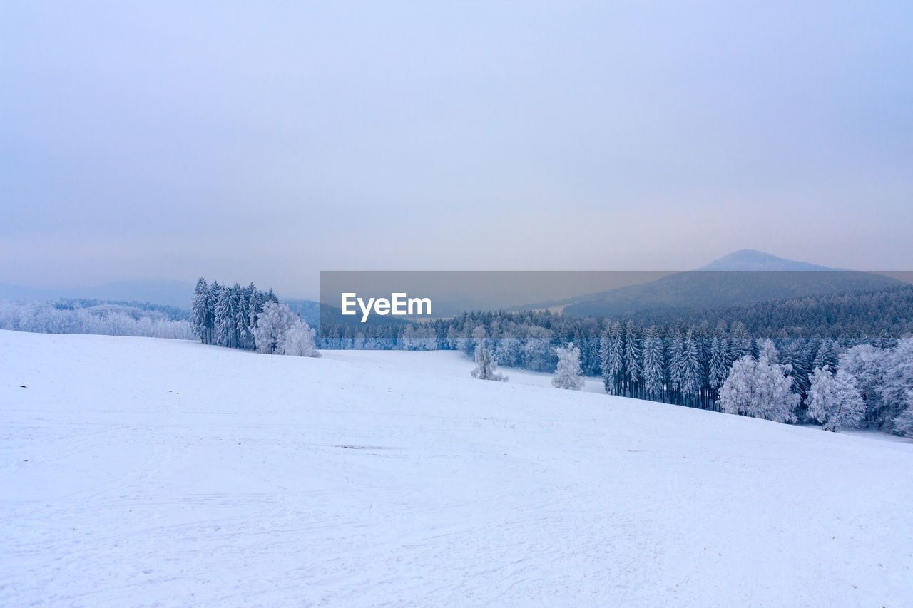 Snow covered landscape against clear sky