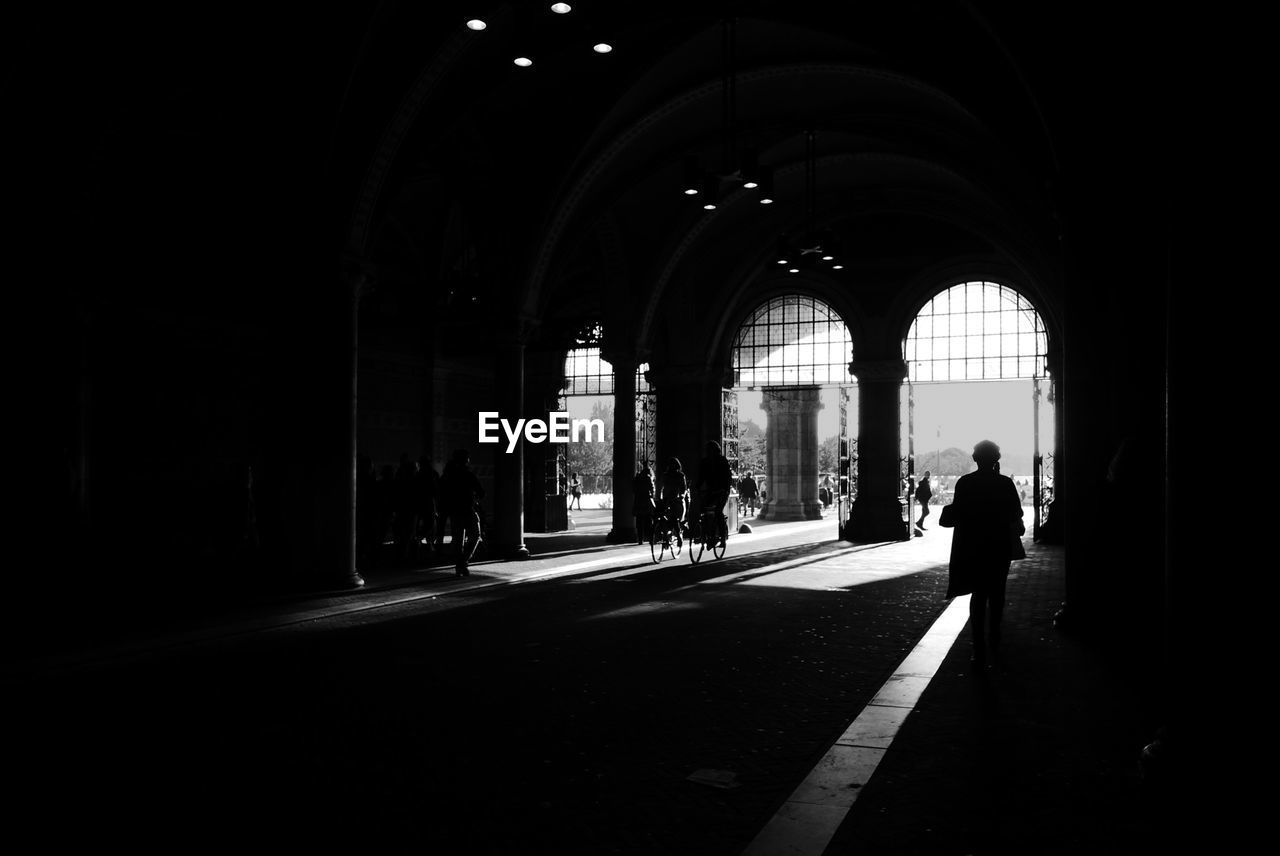 WOMAN WALKING IN ARCHWAY