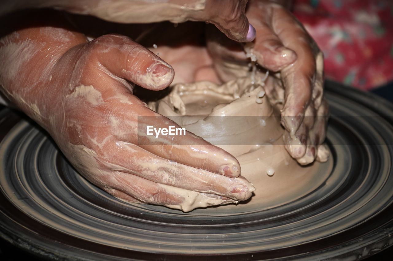 Cropped hands making pot