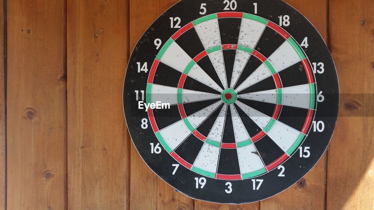 Close-up of dartboard mounted on wooden wall