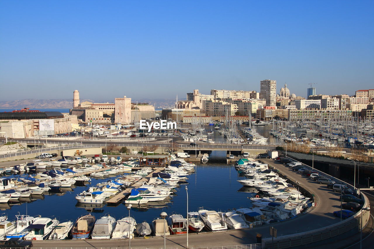 HIGH ANGLE VIEW OF HARBOR AND BUILDINGS AGAINST SKY