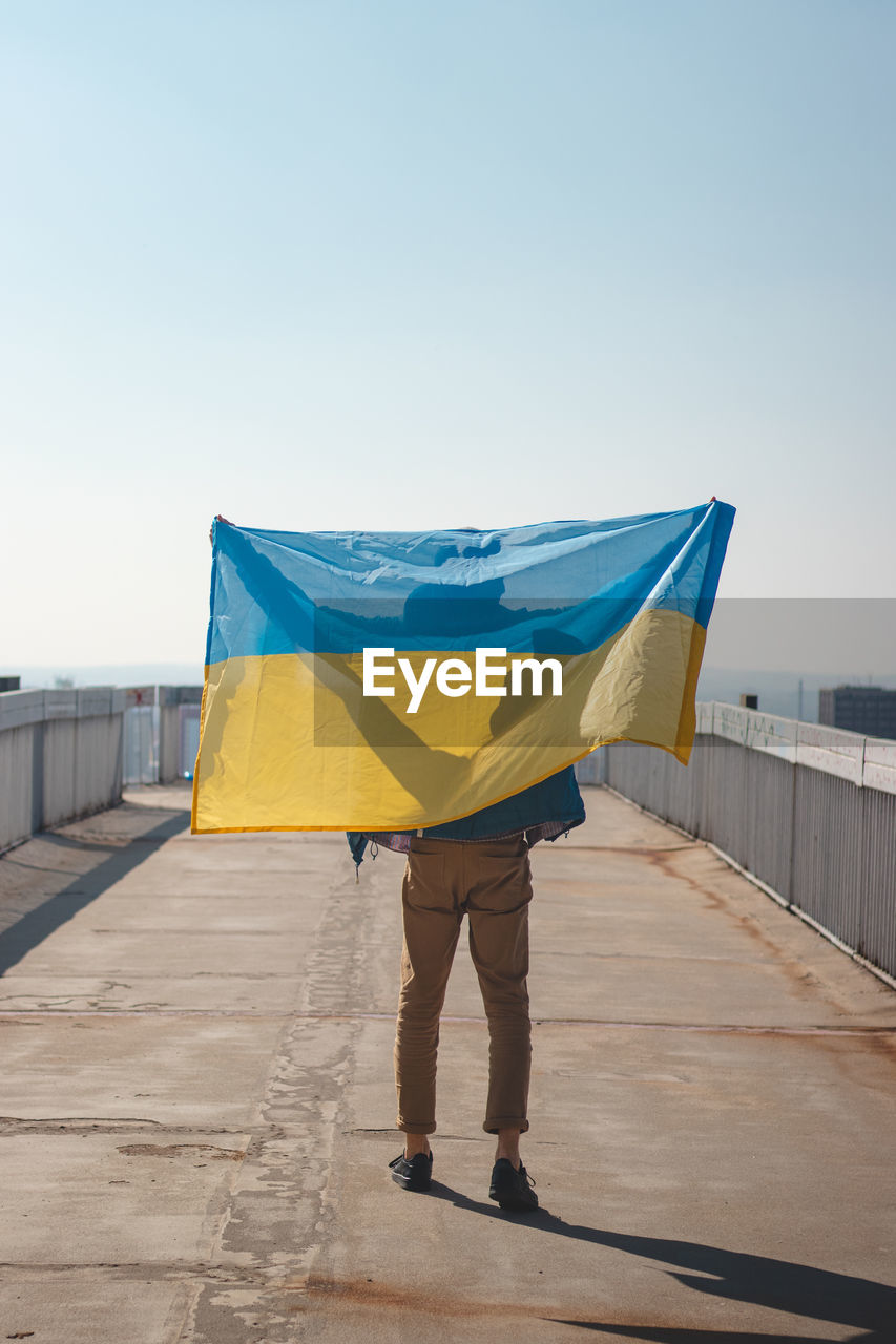 Man with a ukrainian flag goes to join a demonstration in support of ukraine.