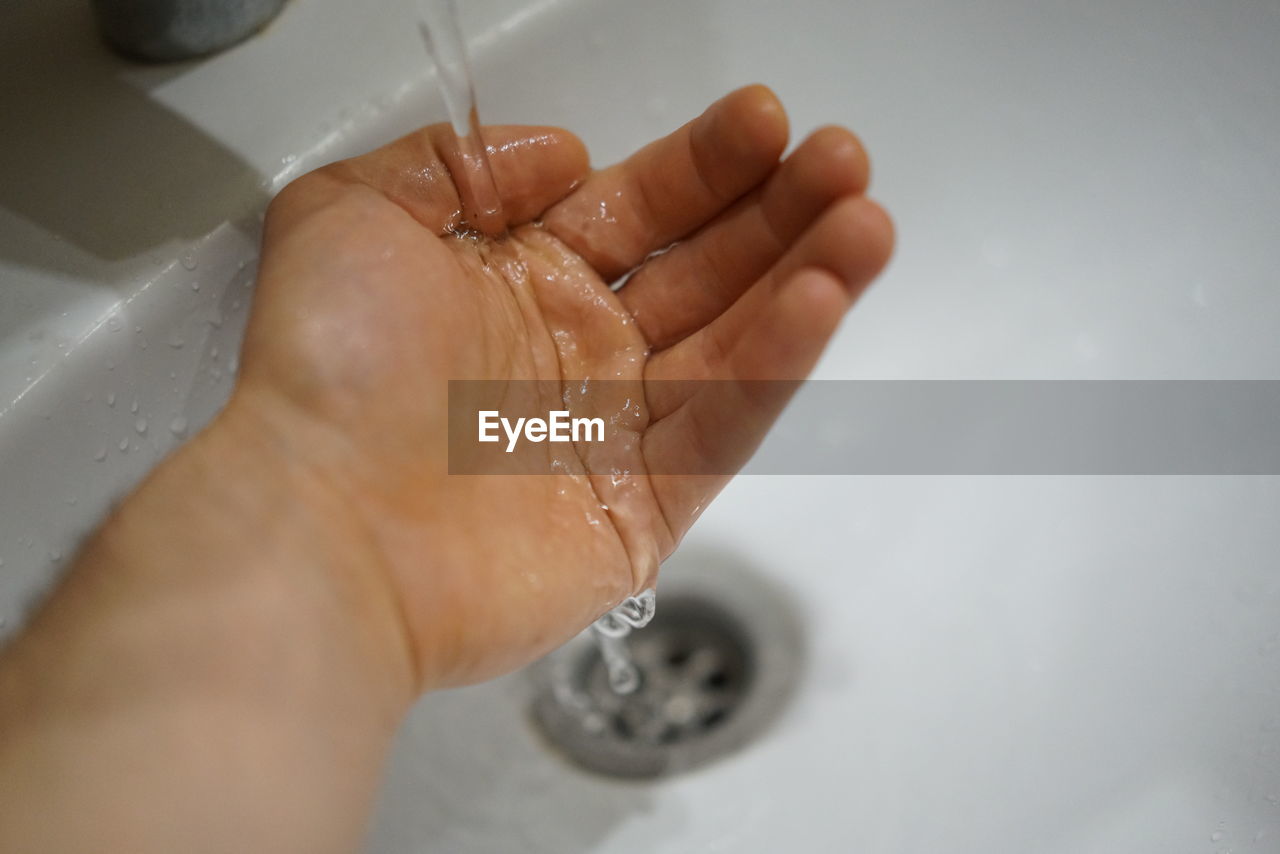 CLOSE-UP OF PERSON HAND HOLDING WATER