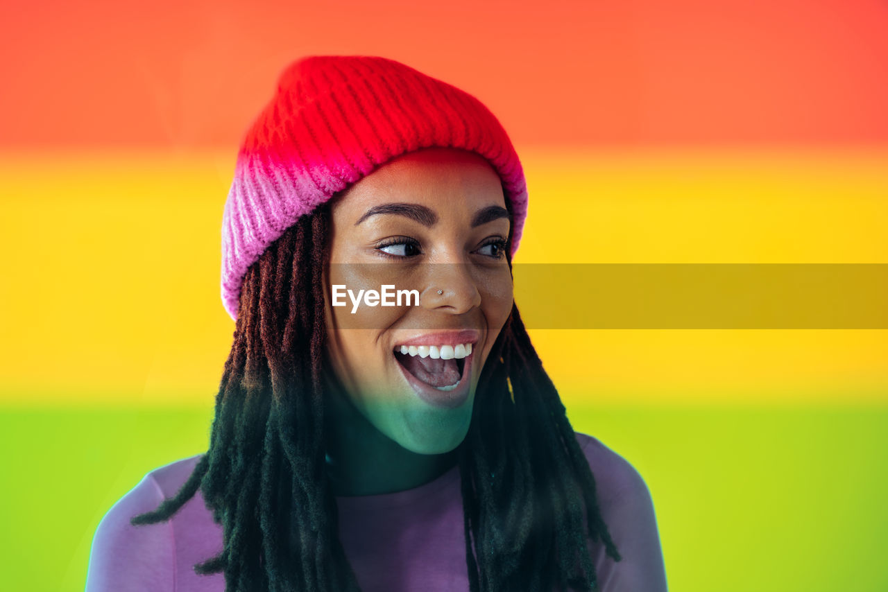 portrait of smiling young woman against yellow background