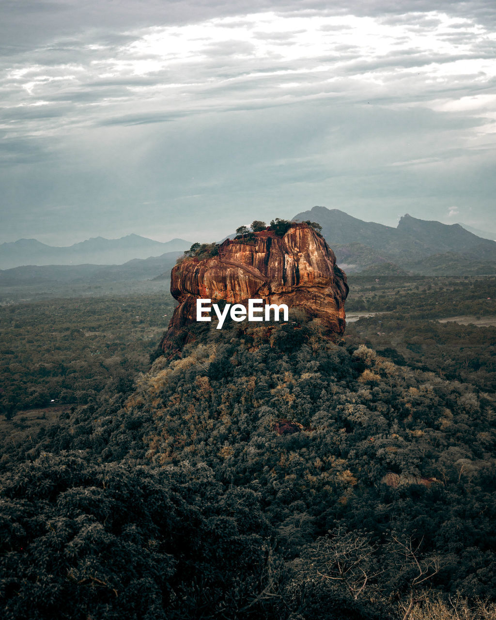 Rock formations on landscape against cloudy sky