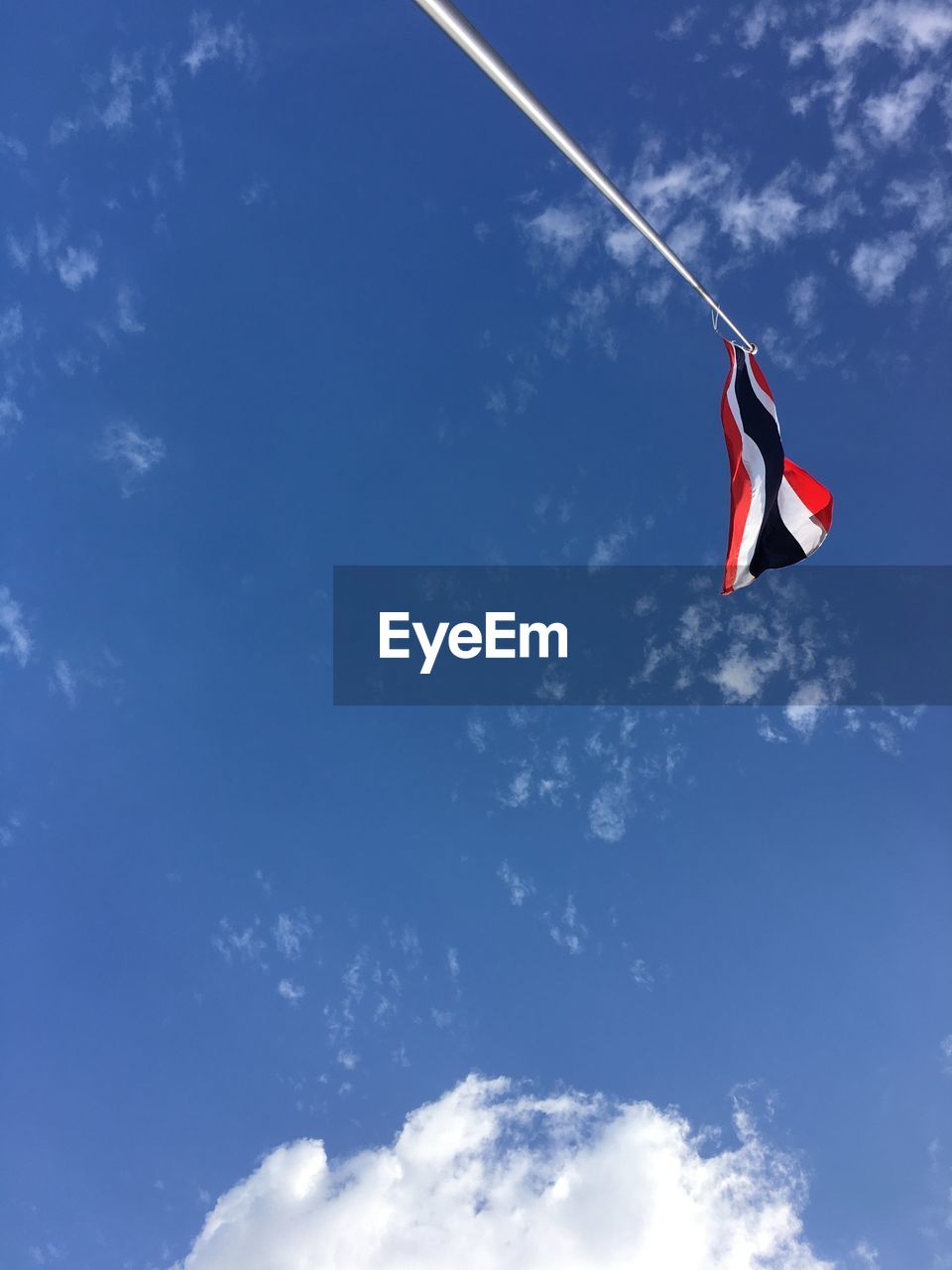 Low angle view of thai nation flag against blue sky