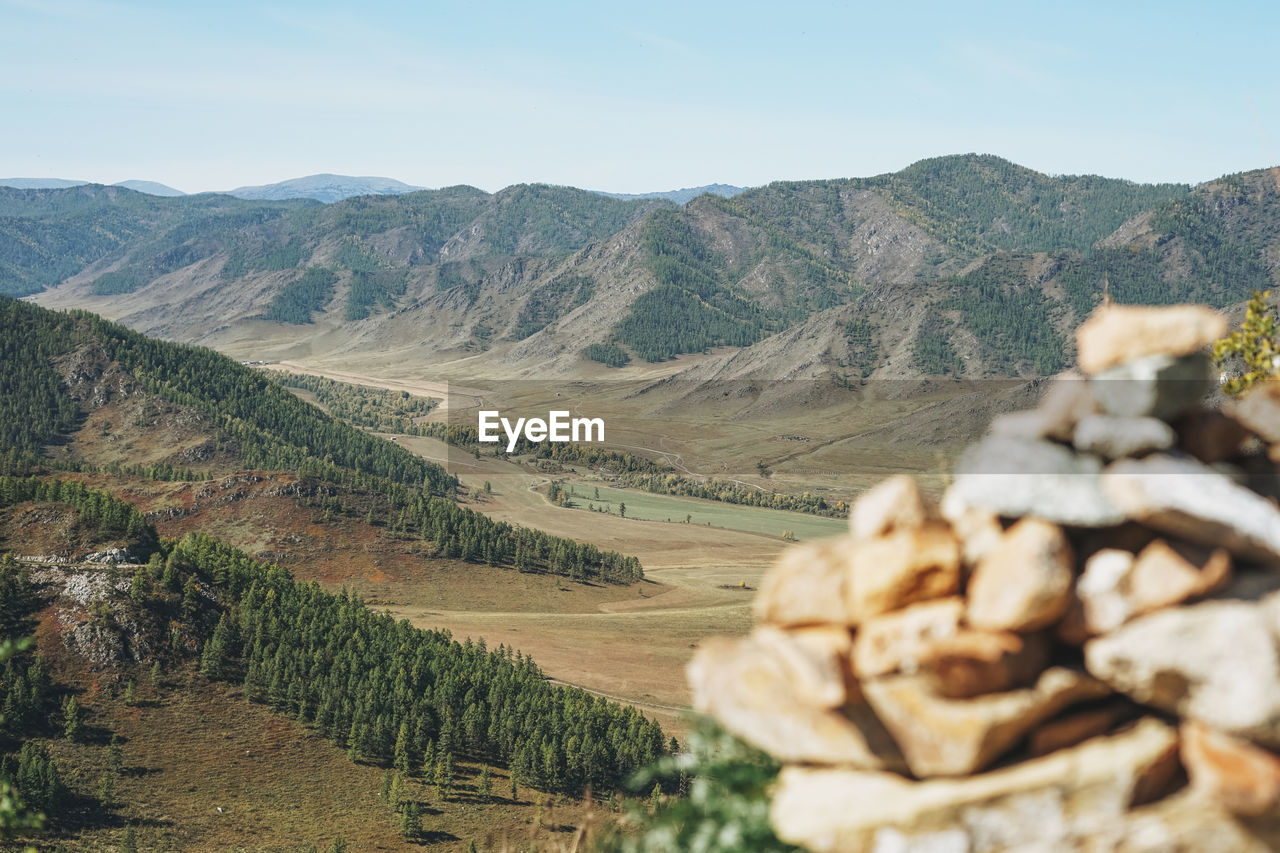 Pile of stones pyramid on background of the valley in altai mountains