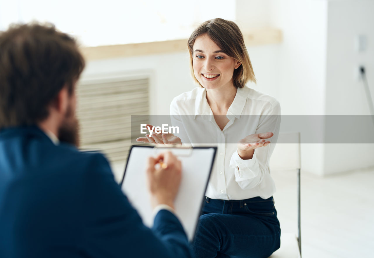 portrait of young woman using mobile phone while sitting at clinic