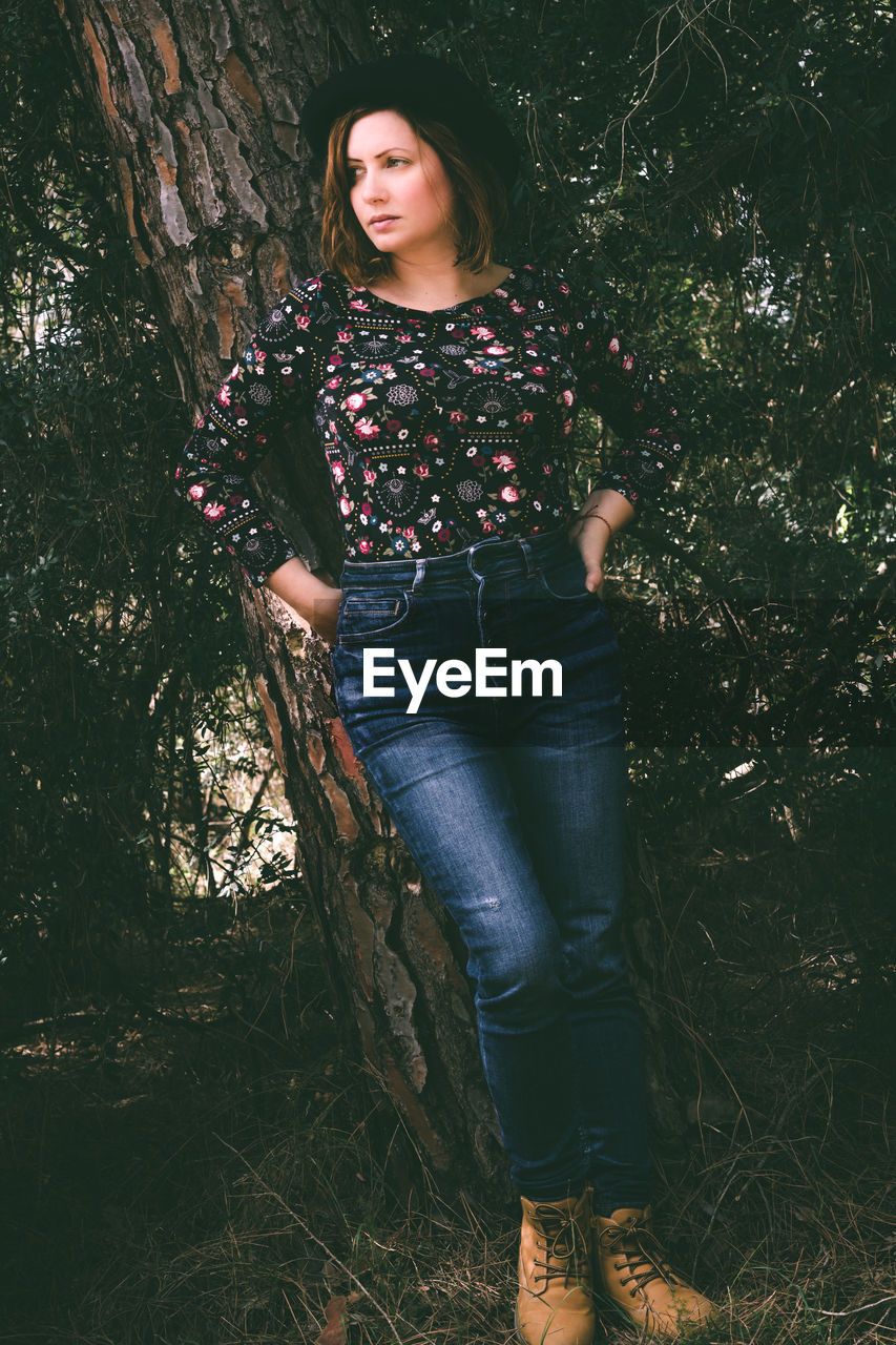 Full length of woman standing in forest