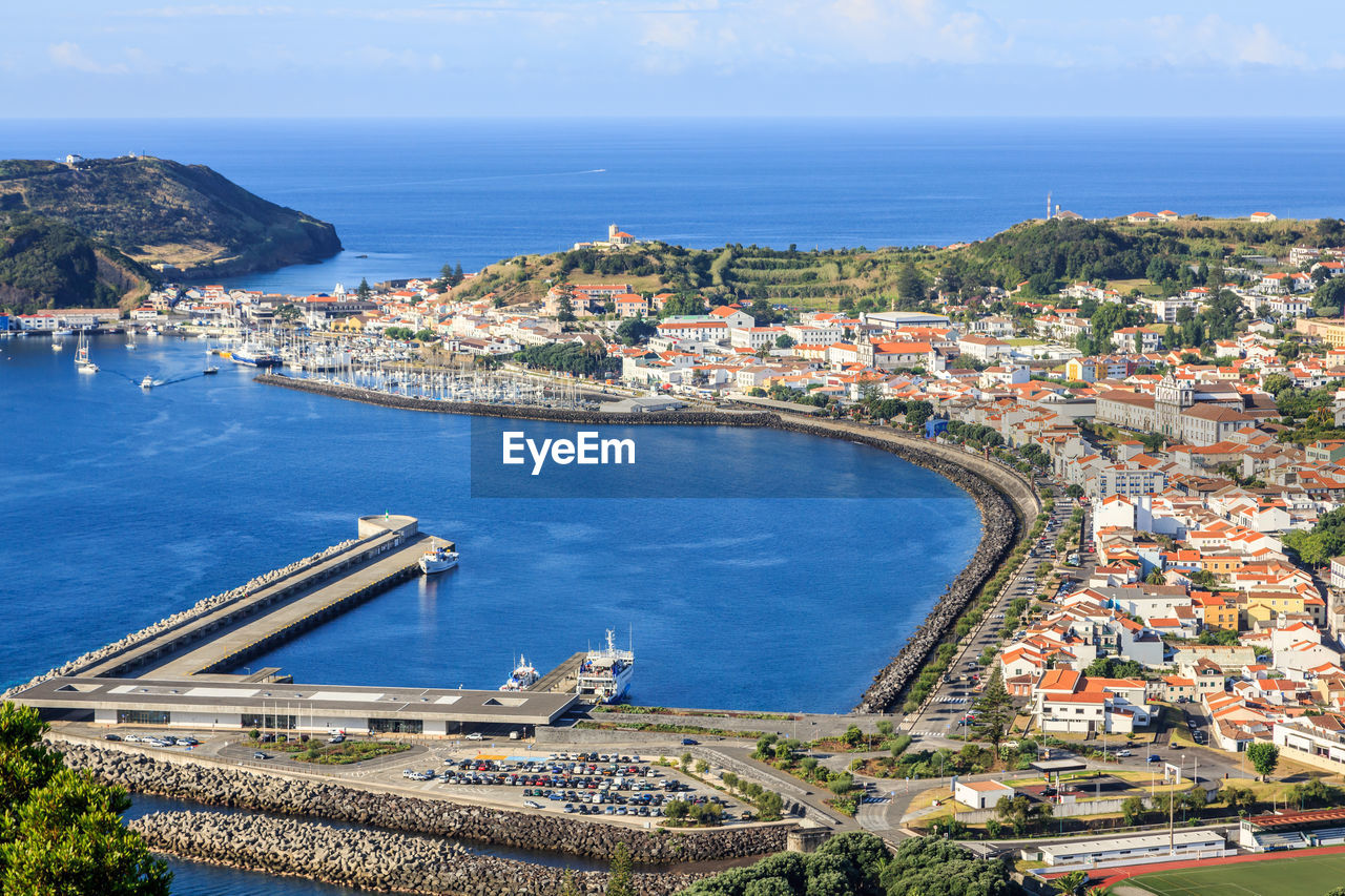 High angle view of city by sea against sky