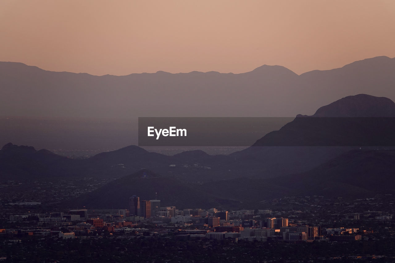 High angle view of downtown tucson and surrounding mountains with orange sunset sky