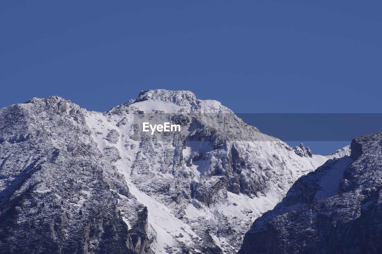 SCENIC VIEW OF SNOWCAPPED MOUNTAIN AGAINST BLUE SKY