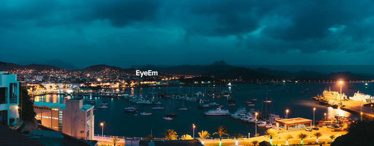 HIGH ANGLE VIEW OF ILLUMINATED CITY BUILDINGS AGAINST SKY