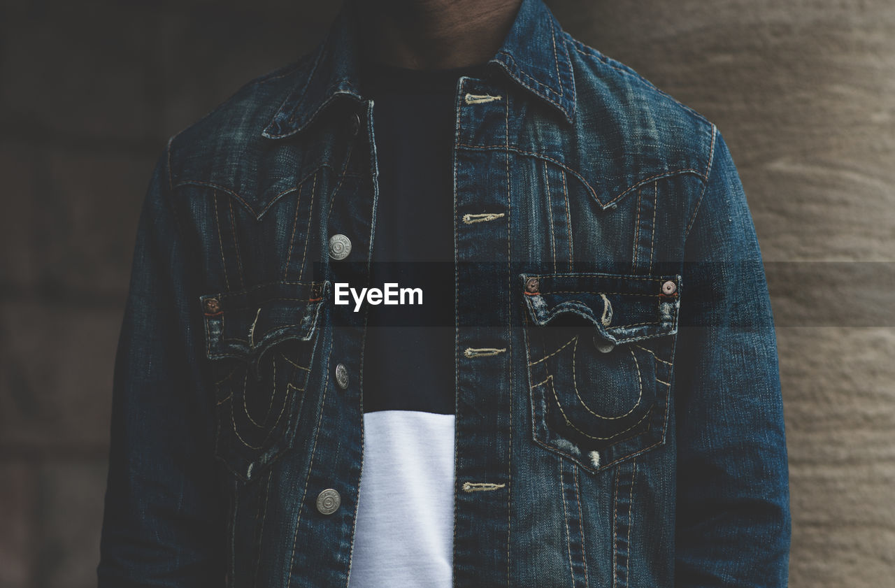 Midsection of person wearing denim jacket