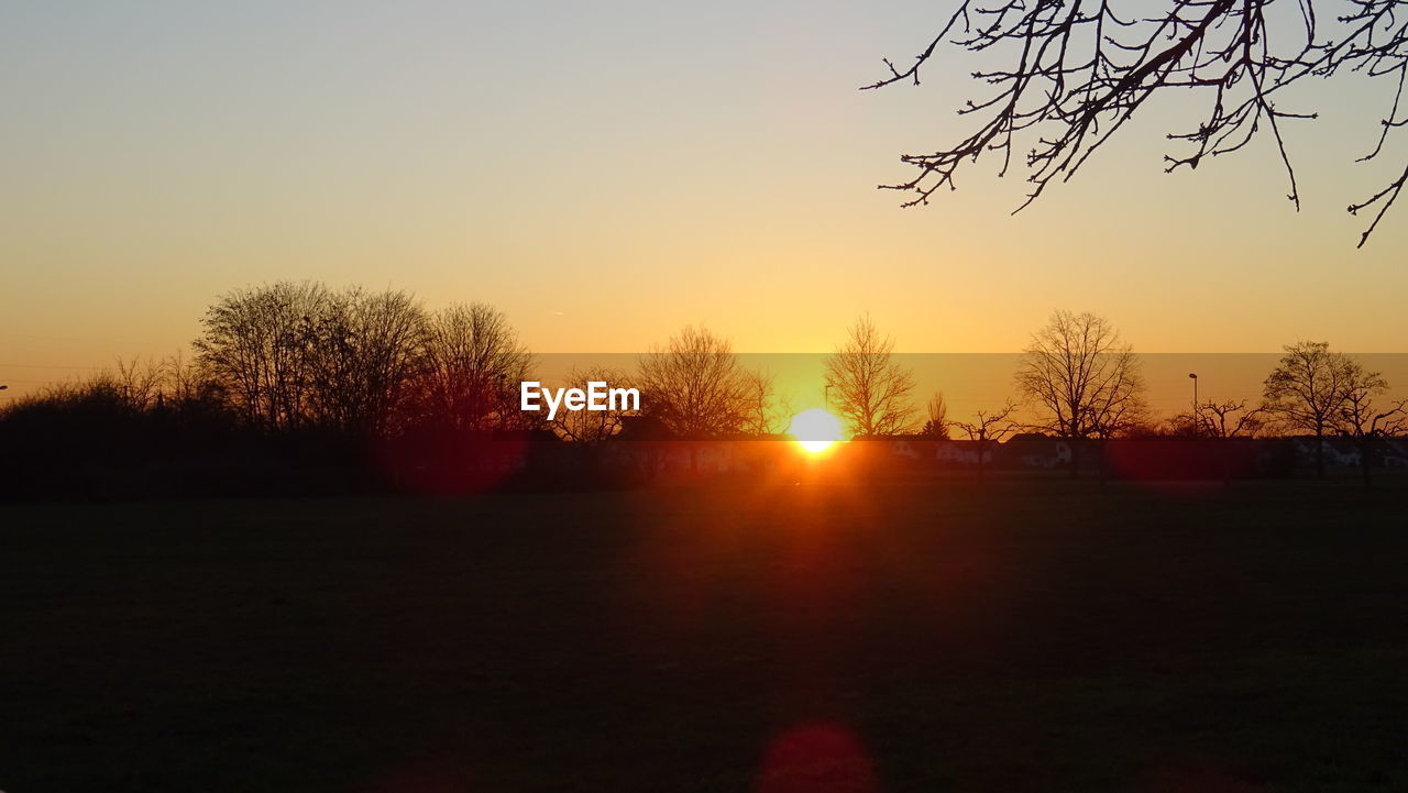 SCENIC VIEW OF SILHOUETTE FIELD AGAINST SKY DURING SUNSET