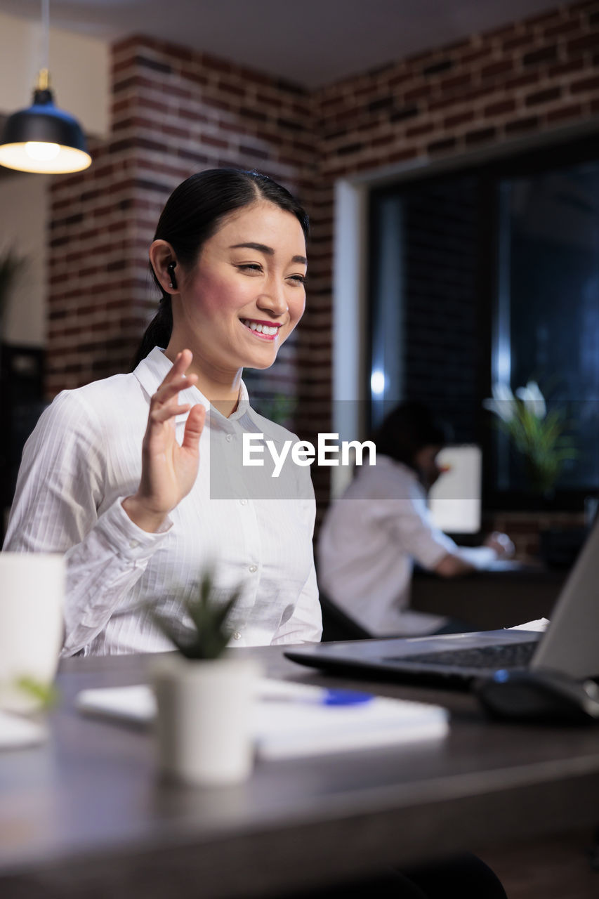 Portrait of smiling businesswoman using laptop at office