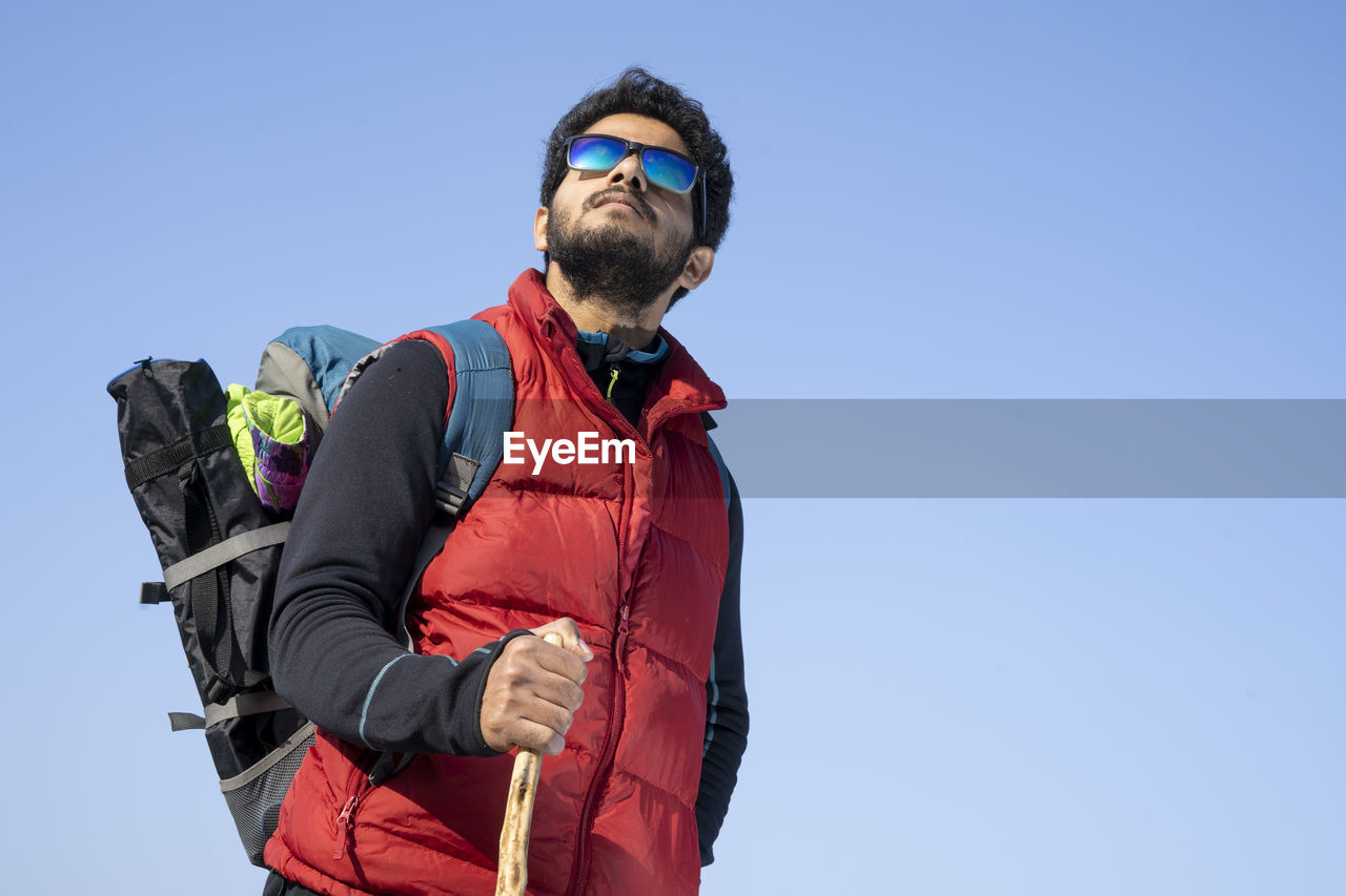 Low angle view of man against clear sky during winter