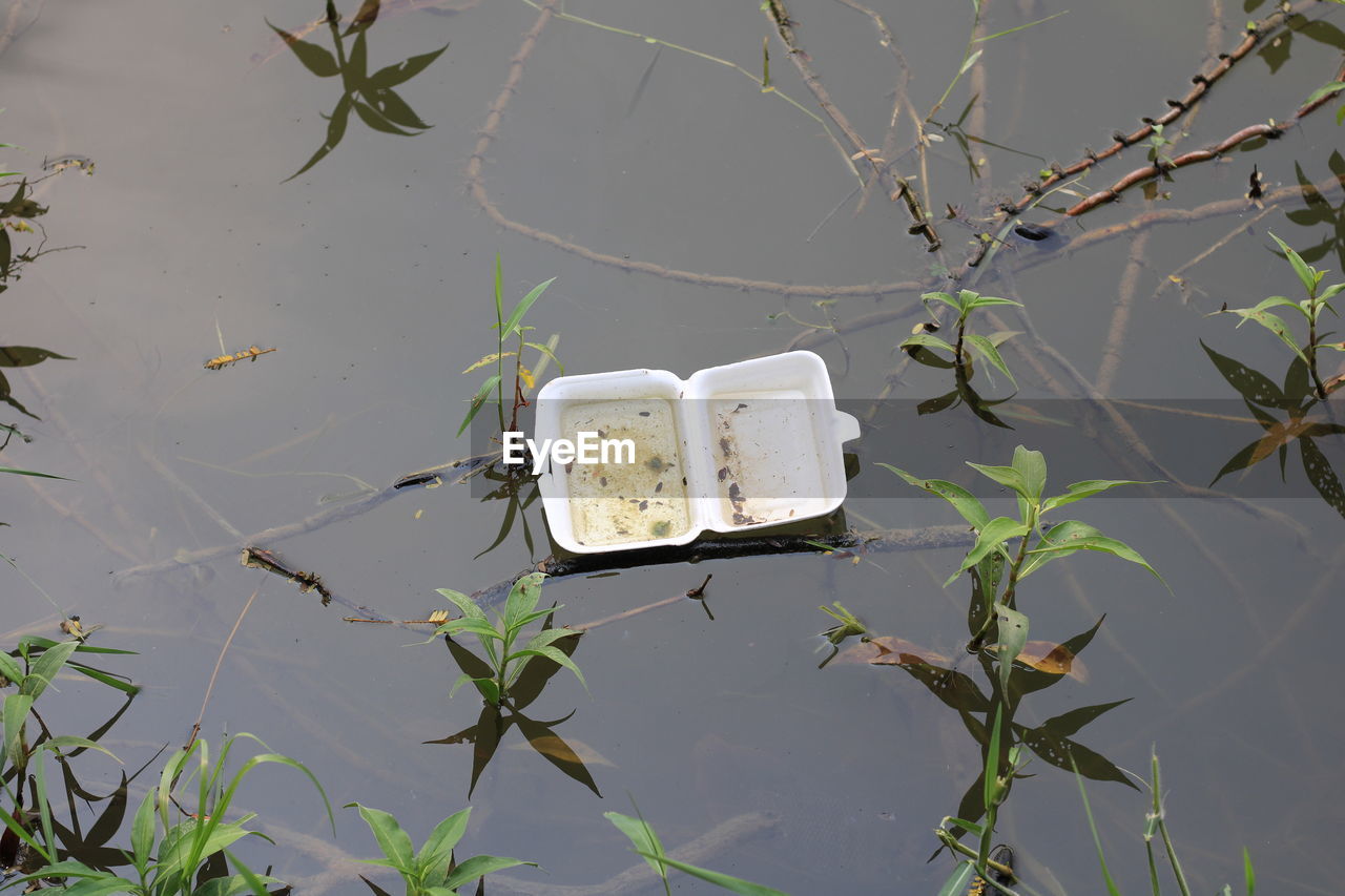 HIGH ANGLE VIEW OF ABANDONED FLOATING ON WATER